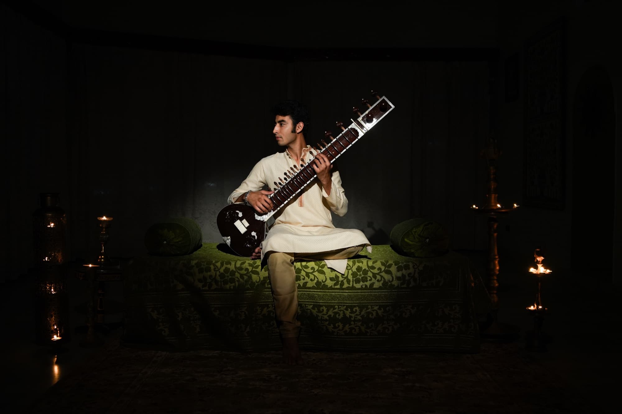 Pradhyuman Singh Hiran seated with his sitar in a candlelit room
